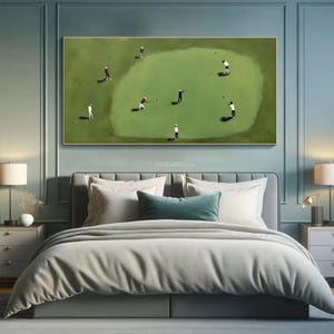 May include: A framed painting depicts a golf course scene with several golfers in action. The artwork features a green golf course with players in white, black, and red attire. The painting is displayed above a bed with gray bedding.