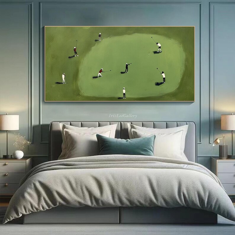 May include: A framed painting depicts a golf course scene with several golfers in action. The artwork features a green golf course with players in white, black, and red attire. The painting is displayed above a bed with gray bedding.