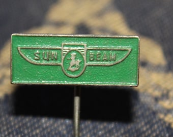 May include: A green metal pin with a silver winged logo that says "SUN BEAM".