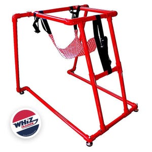 May include: Red metal frame with a red and white hammock-style seat. The frame is designed for a swing-like motion. The frame has a black strap hanging from it. The logo "WHIZ TRAINER" is visible in the lower left corner of the image.