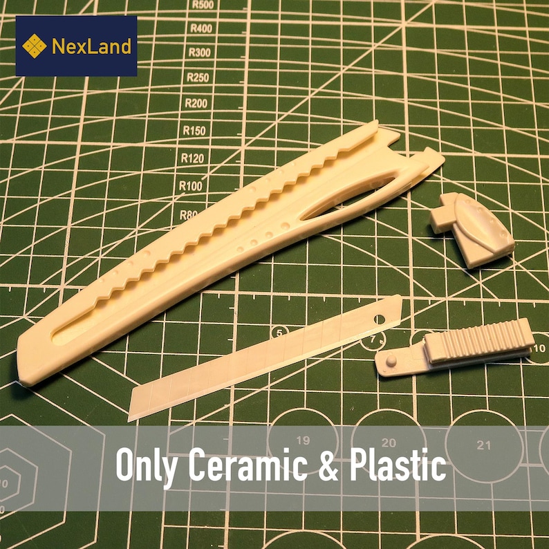 May include: A beige ceramic and plastic craft knife set, including a long knife body, a blade, and two additional parts. The text "Only Ceramic & Plastic" is visible. The set is on a green cutting mat.