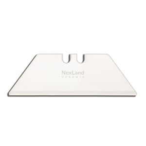 Könnte beinhalten: Eine weiße Keramik-Cutterklinge mit dem Text "NexLand CERAMIC". Die Klinge hat eine trapezförmige Form mit zwei U-förmigen Aussparungen oben. Die Klinge ist zum Schneiden konzipiert.