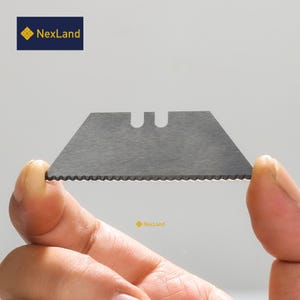 Op de afbeelding: Een zilveren universele mesblad met een gekartelde rand en een klein gat in het midden.