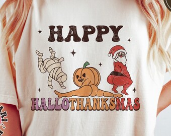 May include: A white t-shirt featuring the text "+ HAPPY HALLOTHANKSMAS" in a retro font. The design includes a pumpkin, a mummy, and Santa Claus in a festive pose.