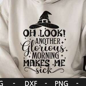 May include: A white hoodie with a black witch hat and the text "OH LOOK! ANOTHER GLORIOUS MORNING MAKES ME SICK" printed on the front.