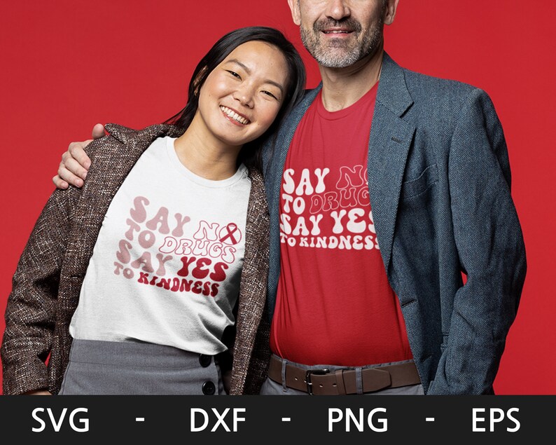 May include: Two people wearing t-shirts with the text "Say No to Drugs Say Yes to Kindness" in a retro font. The woman is wearing a white t-shirt and the man is wearing a red t-shirt.