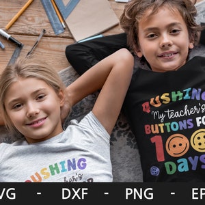Pode incluir: Duas crian&ccedil;as vestindo camisas com o texto "Pushing My Teacher's Buttons For 100 Days" em cores do arco-&iacute;ris. A camisa da menina &eacute; cinza claro e a camisa do menino &eacute; preta.