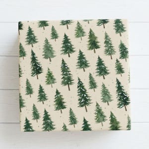 May include: A square sheet of wrapping paper featuring a repeating pattern of watercolor-style evergreen trees in various shades of forest green on a light cream background, with small scattered dots resembling light snowfall.
