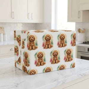 May include: A rectangular box wrapped in white paper featuring a repeating pattern of brown, curly-haired doodle dogs. Each dog illustration is set against a soft, watercolor-style splash of green, pink, and blue hues, creating a consistent design.