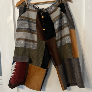 Peut inclure: Short en patchwork avec une taille à cordon et plusieurs poches. Le short est fait de différents tissus, dont le velours côtelé, le denim et la flanelle. Les couleurs sont le marron, le vert, le gris et le rouge.