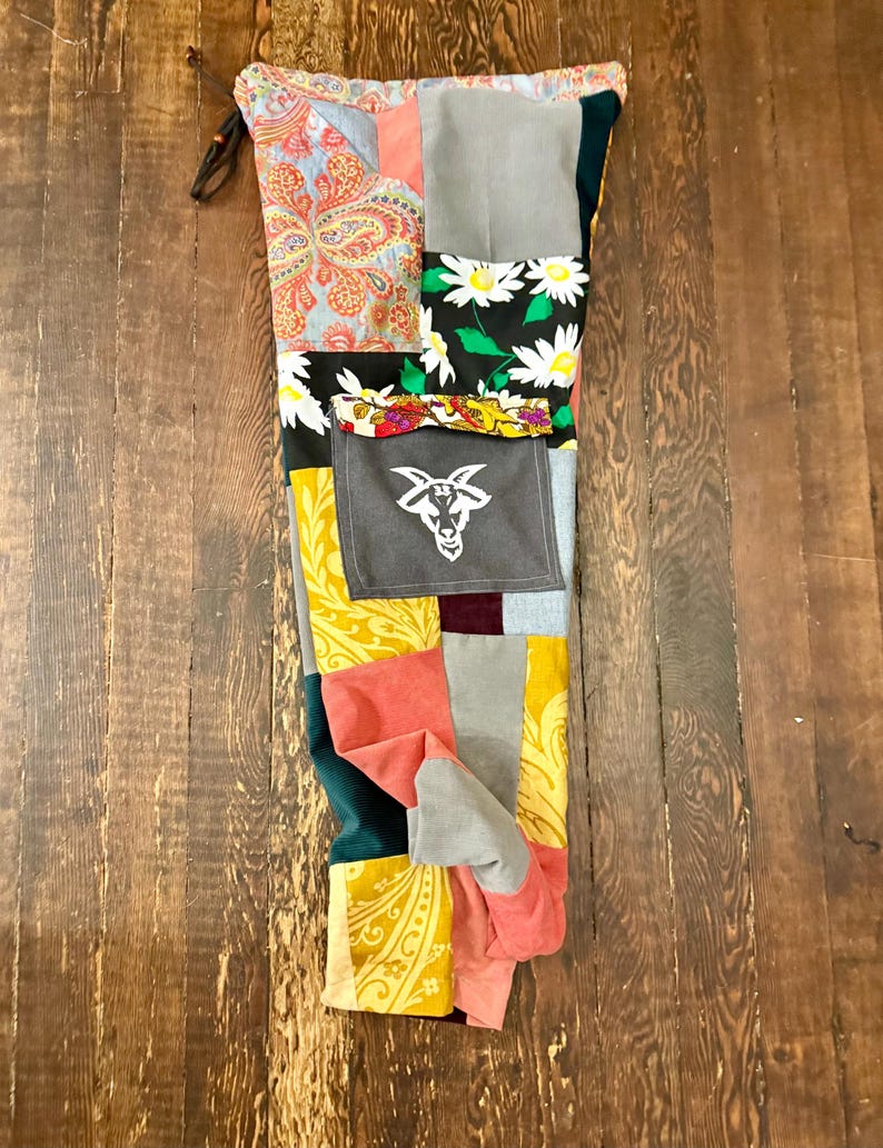 Pu&ograve; includere: Pantaloni patchwork con una variet&agrave; di motivi e colori di tessuto, tra cui paisley, floreali e blocchi a tinta unita. I pantaloni presentano una vita con coulisse e una tasca grigia con una grafica a testa di capra bianca. Il design &egrave; un mix di trame e tonalit&agrave;.