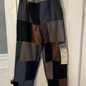 May include: Patchwork pants made from different colored fabrics, including brown, blue, black, and green. The pants have a drawstring waist and a relaxed fit.