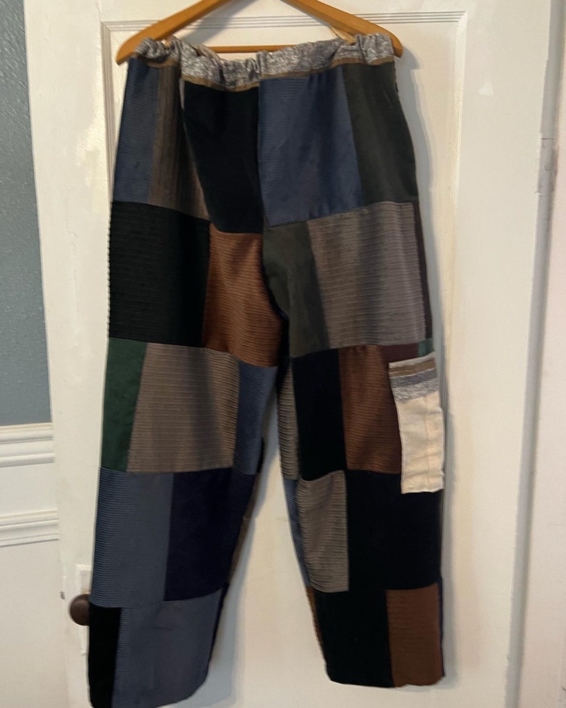 May include: Patchwork pants made from different colored fabrics, including brown, blue, black, and green. The pants have a drawstring waist and a relaxed fit.