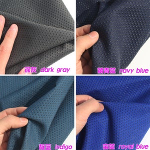 May include: Close-up of four fabric swatches with a textured, dotted surface. The swatches are dark gray, navy blue, indigo blue, and royal blue. The fabric is soft and has a subtle sheen.