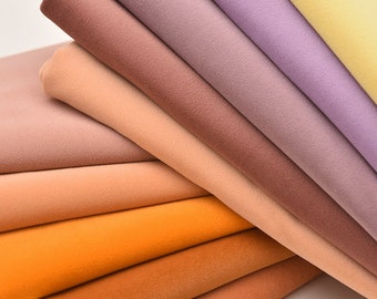 May include: A stack of fabric swatches in various shades of brown, orange, and purple. The fabric is soft and velvety.