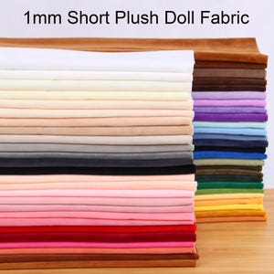 May include: A stack of 1mm short plush doll fabric in a wide variety of colors. The fabric is folded into neat, rectangular layers, displaying a spectrum of shades including white, pink, red, blue, green, yellow, brown, and black.