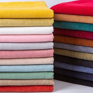 May include: A stack of 20 different colored corduroy fabric swatches. The colors include yellow, beige, white, pink, light pink, peach, light blue, green, tan, red, burgundy, brown, gray, dark gray, black, teal, and navy.