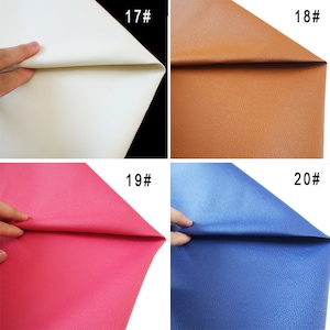 May include: Four samples of faux leather in different colors: white, brown, pink, and blue. Each sample is folded in half to show the texture.