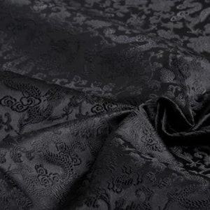 May include: Black fabric with a raised embossed pattern of dragons and clouds. The fabric has a subtle sheen and a soft texture.