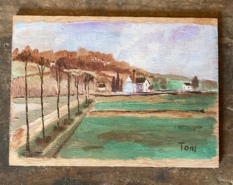 May include: A painting on wood depicting a rural landscape with a white building in the distance. The painting features a row of trees lining a path leading to the building. The sky is a light blue with purple clouds. The painting is signed "Toni" in the bottom right corner.