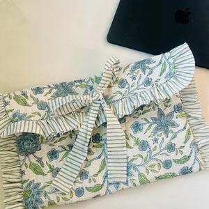 Funda para portátil estampada a mano: Funda de algodón acolchada blanca con estampado floral azul y lazo.