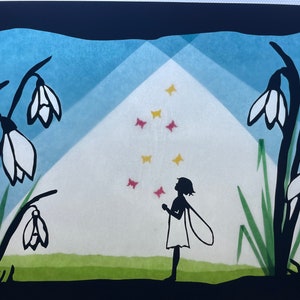 May include: A black silhouette of a fairy with wings standing in a field of white snowdrops. The fairy is looking up at a sky filled with pink and yellow butterflies.