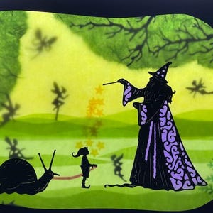 Puede incluir: Ilustración caprichosa que presenta a un mago con una túnica negra con detalles morados, conjurando estrellas. Un niño y un caracol están en primer plano. El fondo es un prado verde con siluetas de hadas y árboles.
