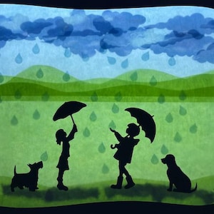 May include: A charming illustration shows a rainy day scene. Silhouetted figures of two children with umbrellas and two dogs are set against a green landscape with blue rain clouds and raindrops. The artwork has a layered paper cut-out style.