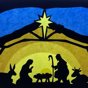 Puede incluir: Una escena de nacimiento en silueta con un recorte negro de un establo, una estrella amarilla brillante y figuras de una persona, un niño en un pesebre, un burro y una vaca sobre un fondo amarillo y azul brillante. Escena de nacimiento clásica.