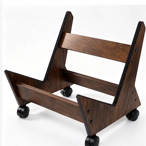 May include: A dark brown wood-grain finish floor stand featuring an open frame design with two horizontal support bars. The stand is equipped with four black swivel casters at the base and includes black protective padding along the inner edges.