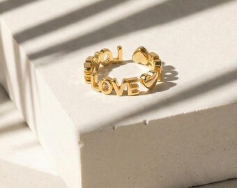 "Love" Ring: Delicate gold ring with the text "Love".
