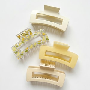 Könnte beinhalten: Ein Set aus drei Keramikbechern mit gesprenkelter, matter Oberfläche. Die Becher sind in den Farbtönen Creme, Hellgrau und Dunkelgrau gehalten. Jeder Becher hat ein schlichtes, minimalistisches Design, ideal für Kaffee oder Tee.
