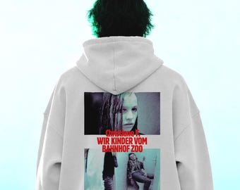 Könnte beinhalten: Ein hellgrauer Kapuzenpullover mit einem Grafikdruck auf der Rückseite. Der Druck zeigt zwei Filmszenen und den roten Text "Christiane F. WIR KINDER VOM BAHNHOF ZOO". Der Hoodie verfügt über eine Kapuze mit Kordelzug und lange Ärmel.