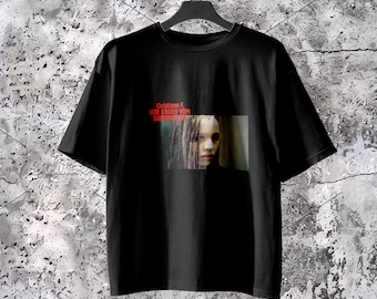 Könnte beinhalten: Ein schwarzes Kurzarm-T-Shirt mit einem rechteckigen Grafikdruck auf der Brust. Der Druck zeigt ein fotografisches Porträt einer Person mit langem Haar und den roten Text Christiane F. WIR KINDER VOM BAHNHOF ZOO über dem Bild.
