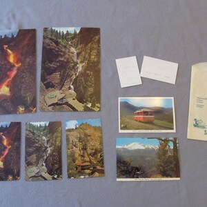 May include: A collection of vintage postcards featuring scenic views of Seven Falls, a waterfall in Colorado. The postcards show the falls from different angles, including a close-up of the water cascading down the rocks. The postcards are in good condition and would be a great addition to any collection.