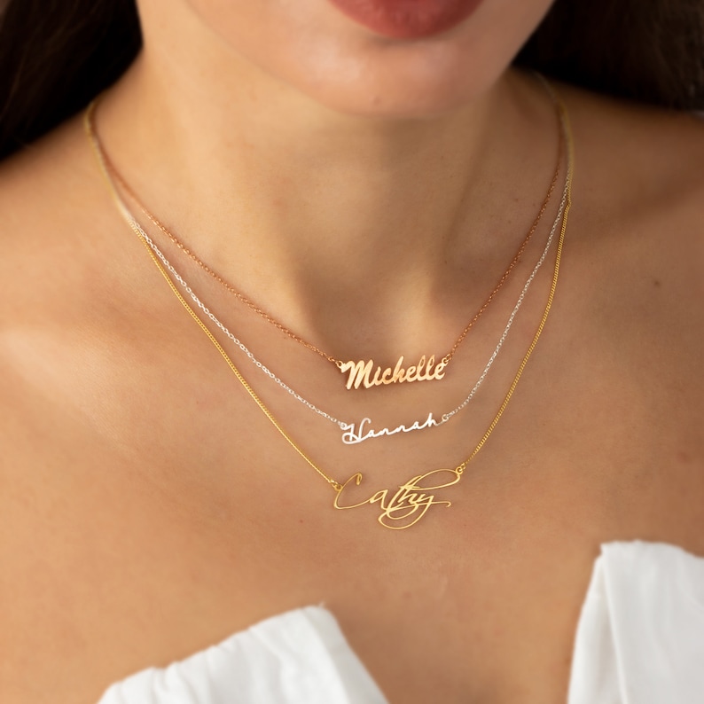 Layered gold and silver name necklaces with custom names Michelle,Hannah, and Cathyin script fonts. Chain lengths are 15 inches, 16 inches, and 18 inches. Perfect personalized jewelry for women, ideal for gifting on special occasions.