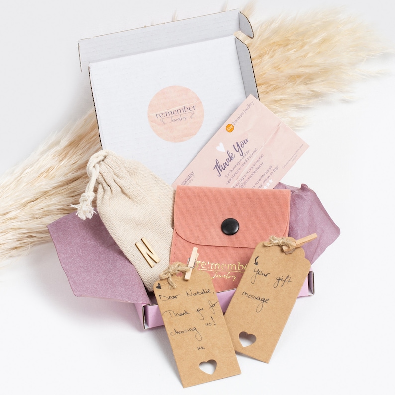 Sterling silver jewelry in a custom gift box with a thank you card, personalized note, and fabric pouch. Includes a pink envelope, kraft gift tags with handwritten messages, and tissue paper, creating a premium unboxing experience, ideal for gifts.