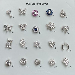May include: Twenty different 925 sterling silver nose rings with various designs, including butterflies, flowers, stars, and moons. Each ring is adorned with sparkling cubic zirconia stones.