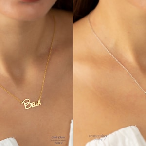 Side-by-side image of two custom name necklaces: one gold-plated with Bella on a cable chain, and one sterling silver with Caroline on a cable chain. Both necklaces feature different cursive fonts, showcasing elegant, personalized jewelry options