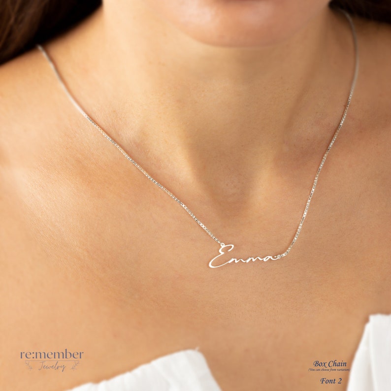 Sterling silver custom name necklace with Emma in a delicate cursive font, showcased on a model wearing a fine box chain. Elegant and personalized jewelry, perfect for gifts or daily wear, customizable with different names and font styles.