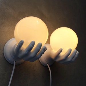 Set of 2 sculptural porcelain wall lamps, ceramic hand with glass ball lamp