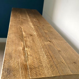 May include: A rustic wooden table top with a natural wood finish. The table has a simple design with a rectangular top and hairpin legs.