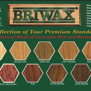 May include: A green and brown label with the text "BRIWAX" in large white letters. The label also includes the text "A Reflection of Your Premium Standards" and "A Natural Blend of Carnauba Wax and Beeswax". Below the text are 12 hexagonal color swatches labeled with different wood stain colors, including Clear, Golden Oak, Dark Oak, Light Brown, Rustic Pine, Antique Mahogany, Red Mahogany, Teak, Tudor Brown, Dark Brown, and Ebony.