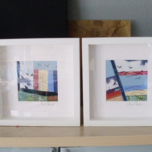 Peut inclure: Deux images encadr&eacute;es blanches avec de l'art abstrait color&eacute; &agrave; l'int&eacute;rieur. L'art est fait de chutes de tissu et a une palette de couleurs bleue, rouge et jaune. Les images sont accroch&eacute;es &agrave; une &eacute;tag&egrave;re en bois clair.