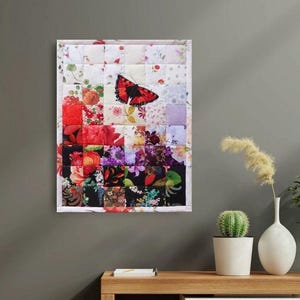 Può includere: Una trapunta patchwork con una farfalla rossa e nera. La trapunta è composta da quadrati di tessuto floreale nei toni del rosso, rosa, viola e nero, creando un vivace e artistico arazzo da parete.