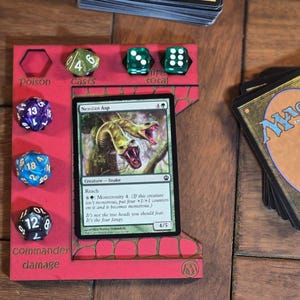 May include: A red wooden game board with a Magic: The Gathering card, "Nesslan Asp", and dice. The board has labels for "Poison", "Cases", "Total", and "Commander Damage".