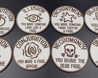 May include: Eight round wooden tokens with white centers and brown edges. Each token features a different spell name and description, such as "Transmutation" and "You turn someone into a frog."