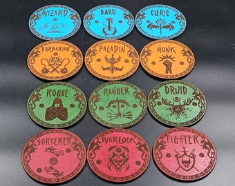 Könnte beinhalten: Zwölf Holz-Untersetzer mit verschiedenen Dungeons and Dragons-Charakterklassen, darunter Zauberer, Barde, Kleriker, Barbar, Paladin, Mönch, Schurke, Waldläufer, Druide, Zauberer, Hexenmeister und Krieger. Jeder Untersetzer hat ein einzigartiges Design und den Klassennamen.