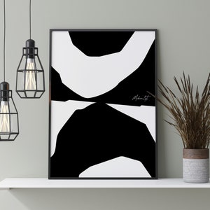 Op de afbeelding: Zwart-witte abstracte kunstprint met de tekst "Modern Art" in wit schrift. De print is ingelijst in een zwart frame en wordt getoond op een wit rek met een bruine en grijze vaas met gedroogd gras.