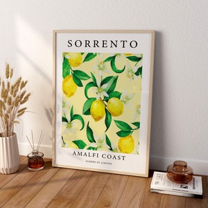 May include: A framed print with a yellow background and a pattern of green leaves, white flowers, and yellow lemons. The print says "SORRENTO AMALFI COAST ALBERO DI LIMONE".